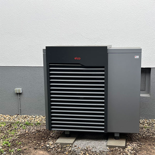 Eine von KUHN montierte Wärmepumpe Wärmepumpe vor einem Wohnhaus