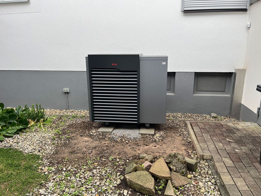 Wärmepumpe vor einem Wohnhaus